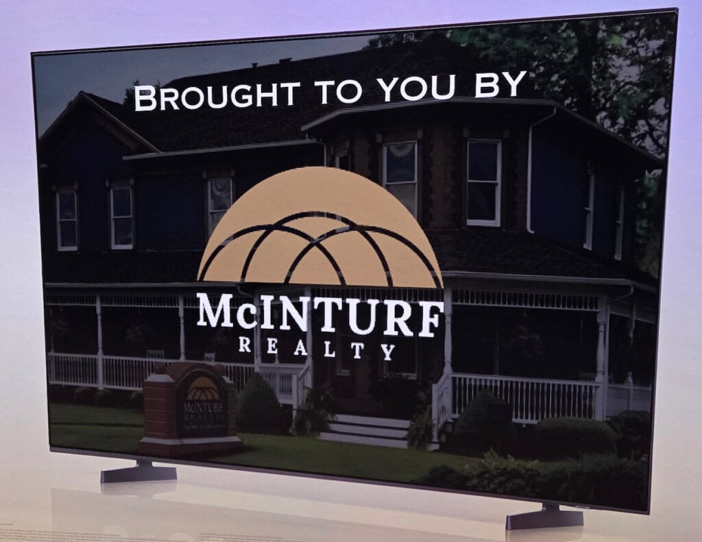 TV with an image of a home and the words "Brought to You By" with the McInturf Realty logo.